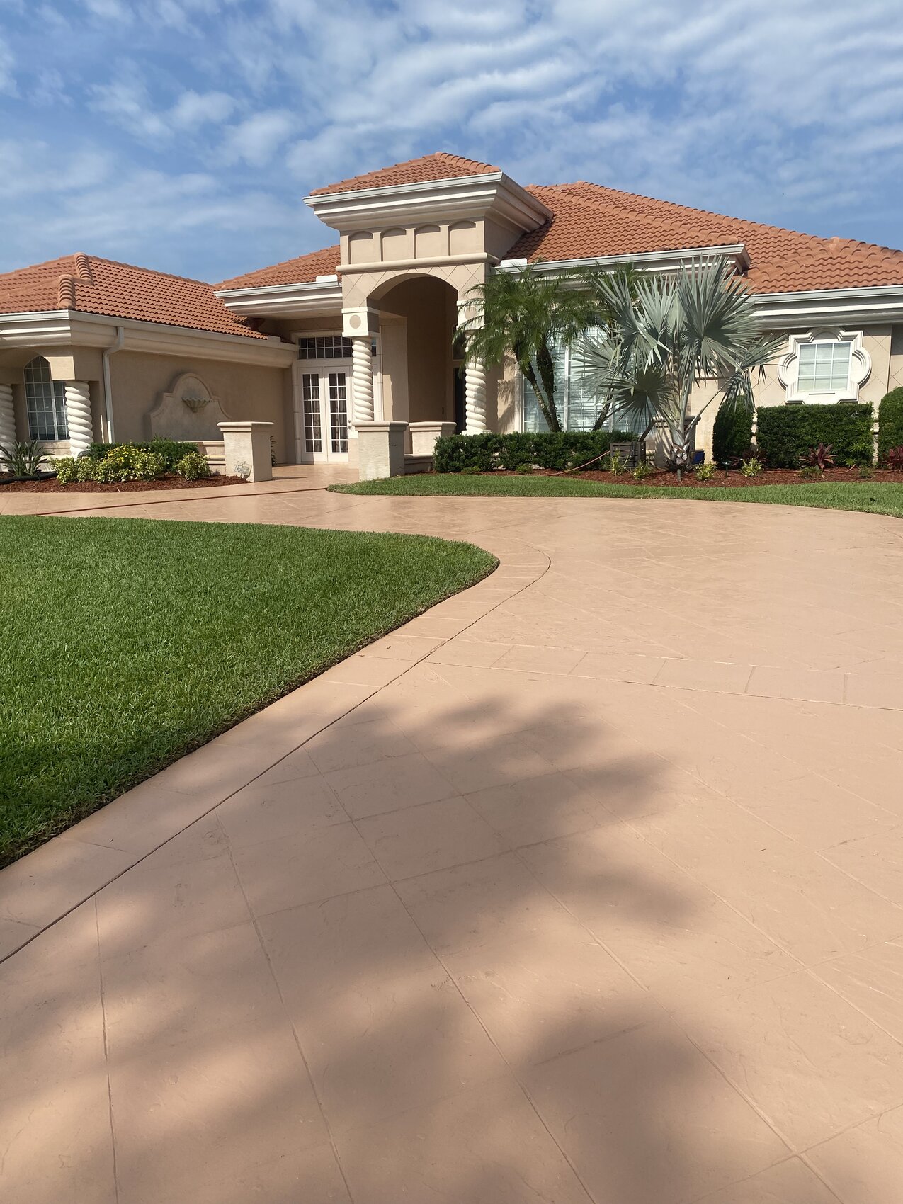 Stamped and dyed decorative concrete driveway leading to a Holly Hill home