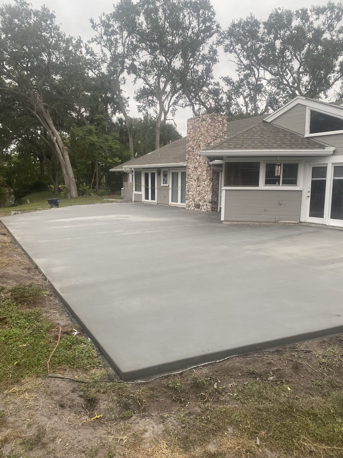 Newly poured concrete patio slab behind a home