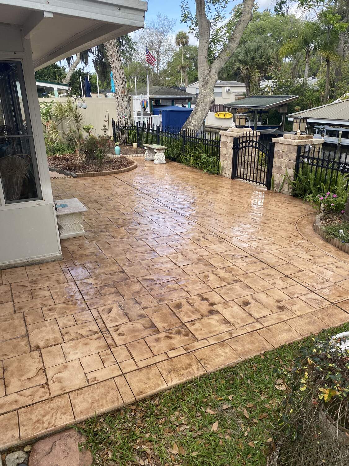 Stamped and dyed concrete patio leading to a gated dock area